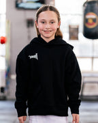 Girl wearing the kids black Team Teremoana Hoodie, front view