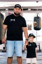 Dad and son in matching Team Teremoana caps and tees in the gym