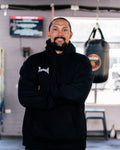 Teremoana wearing the black Team Teremoana Hoodie, front view with the wordmark on the chest