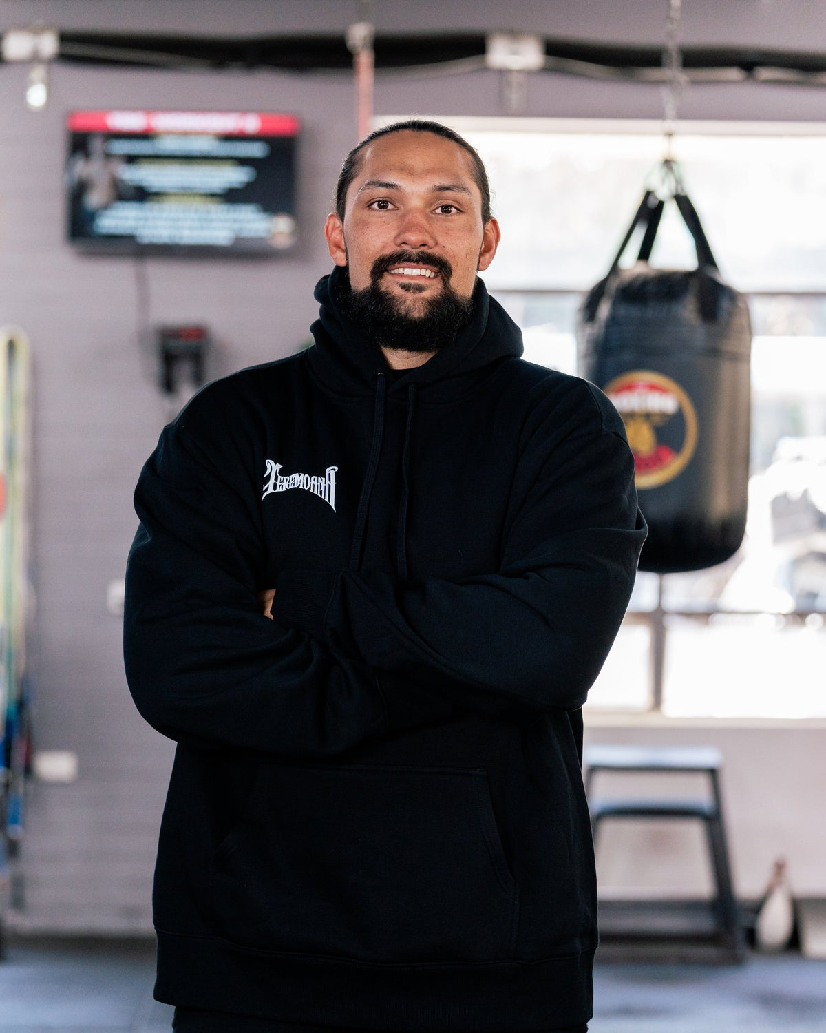 Teremoana wearing the black Team Teremoana Hoodie, front view with the wordmark on the chest