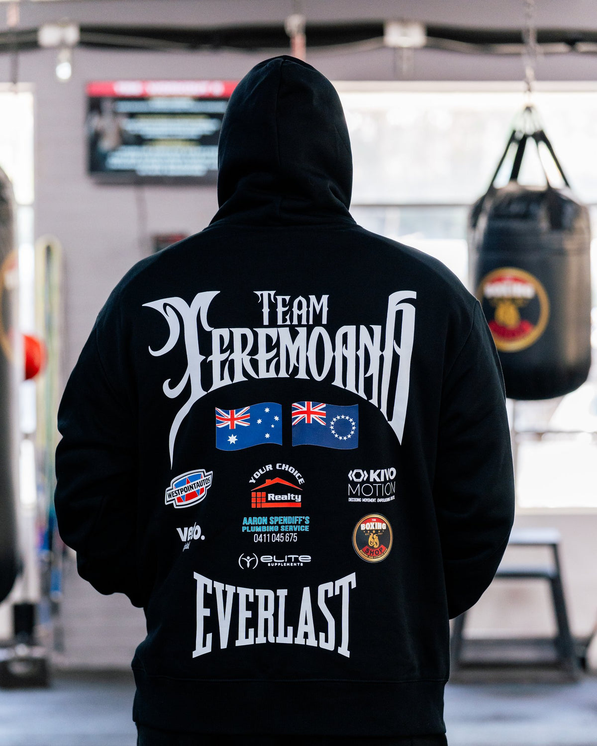 Back of the black Team Teremoana Hoodie showing the full back print with the Australian and Cook Islands flags and sponsor logos