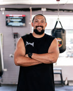 Teremoana wearing the black Team Teremoana Muscle Tank, front view with the wordmark on the chest