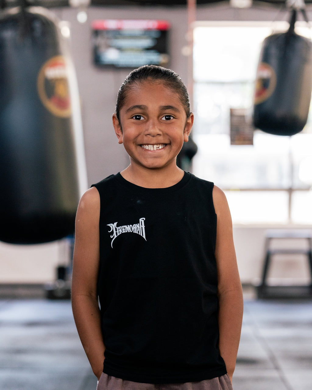 Child wearing the kids black Team Teremoana Muscle Tank, front view