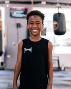 Smiling child in the kids black Team Teremoana Muscle Tank, front view