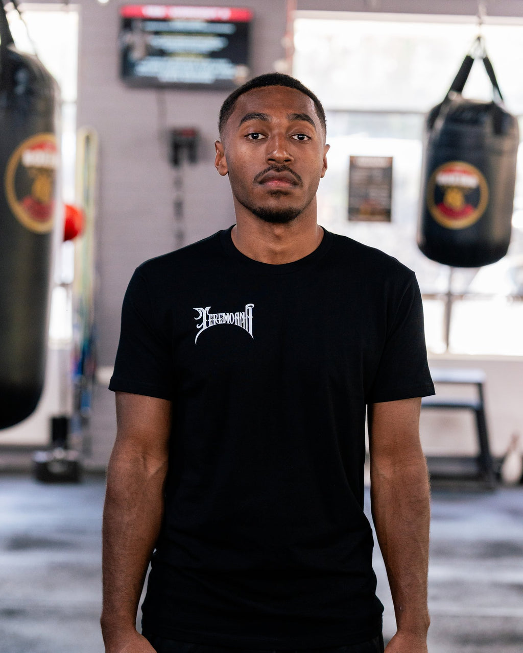 Teremoana wearing the black Team Teremoana Tee in the gym, front view