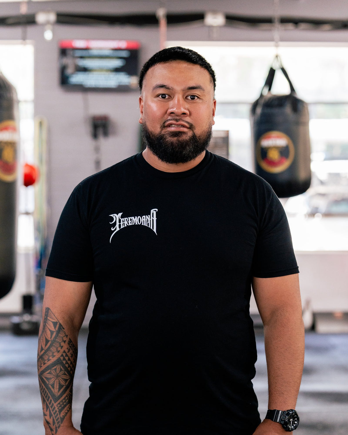 Teremoana in the black Team Teremoana Tee, relaxed front view in the gym