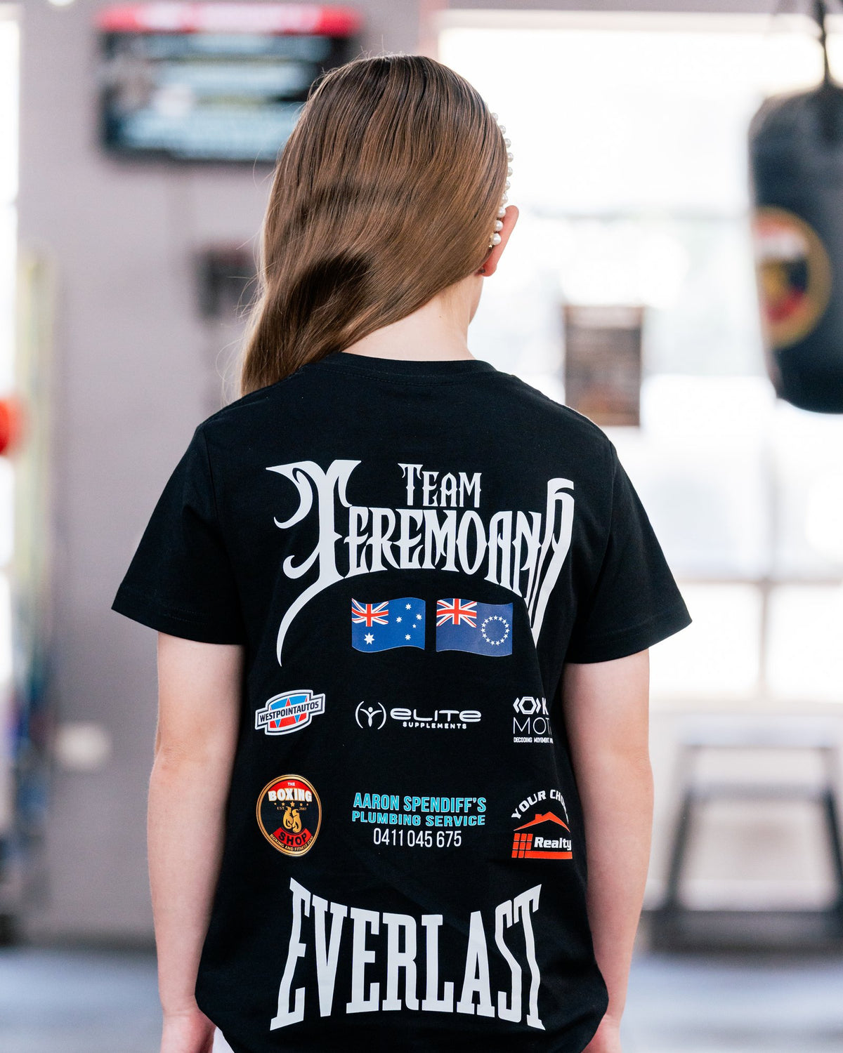 Back view of the kids black Team Teremoana Tee with the flags and sponsor print