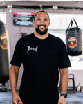 Teremoana wearing the black Team Teremoana Tee, front view with the wordmark on the chest