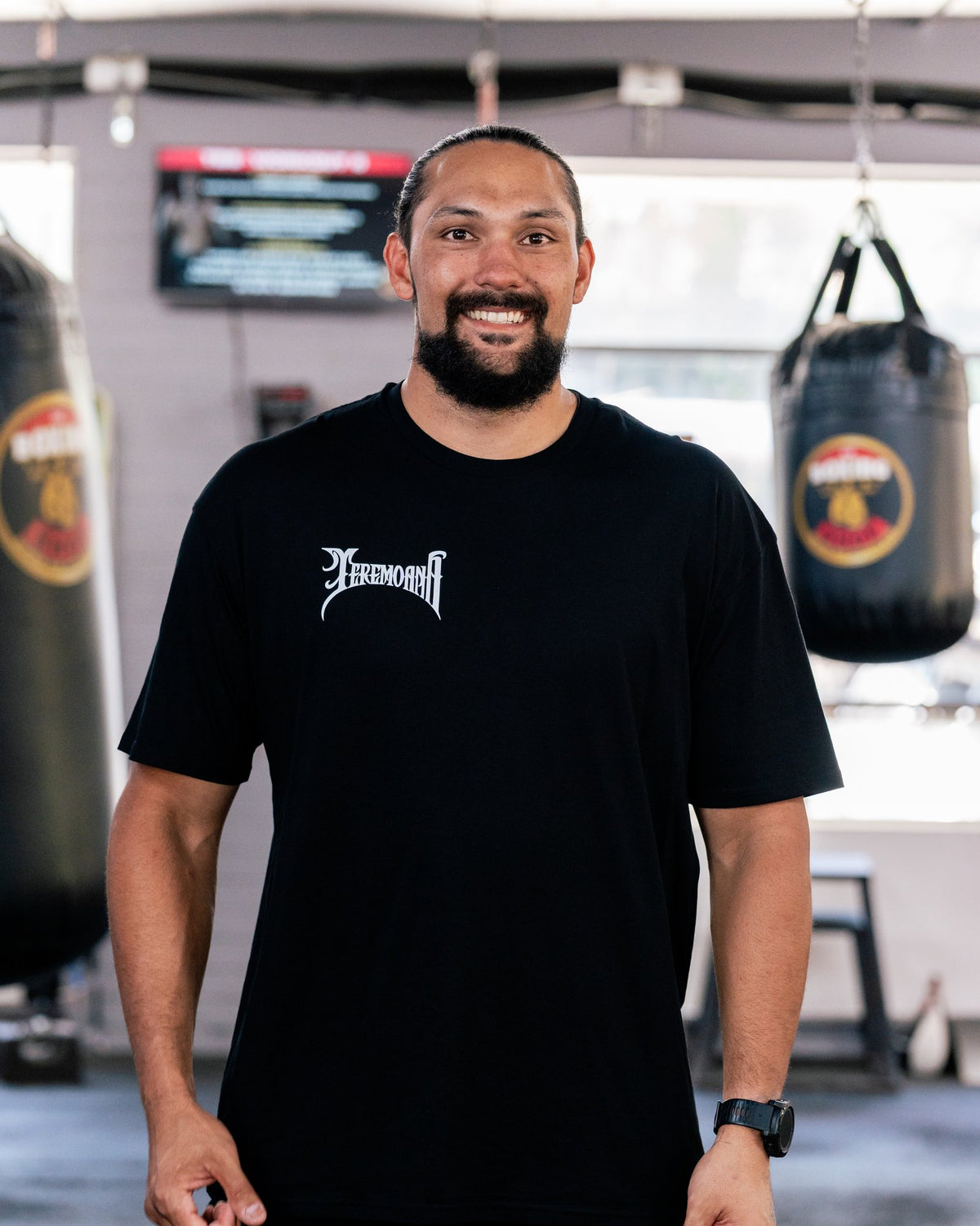Teremoana wearing the black Team Teremoana Tee, front view with the wordmark on the chest