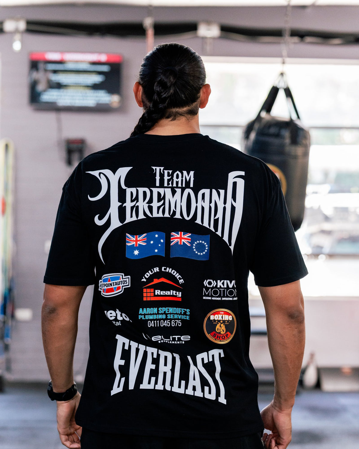 Back of the black Team Teremoana Tee showing the full back print with the Australian and Cook Islands flags and sponsor logos