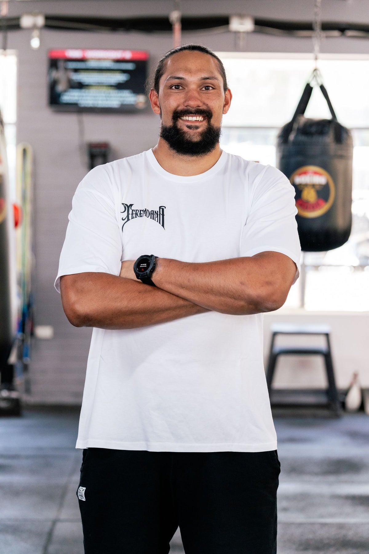Teremoana wearing the White Team Teremoana tee, arms crossed